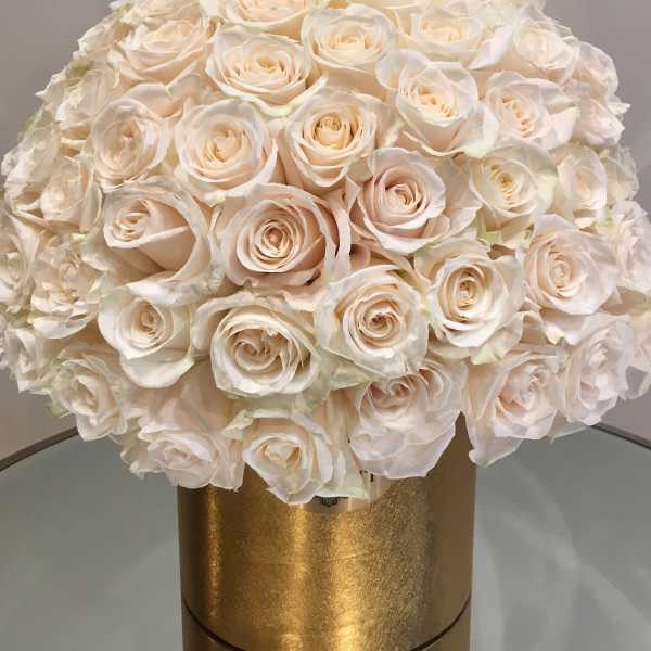 Round bouquet of ivory roses in a gold box