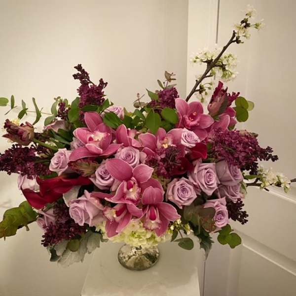 Pink orchids and lavender roses in a glass vase