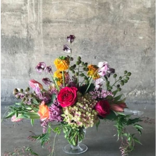 Mixed bouquet with pink and purple flowers in a clear glass vase