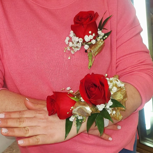Red rose corsage and boutonniere with white baby's breath and gold ribbon