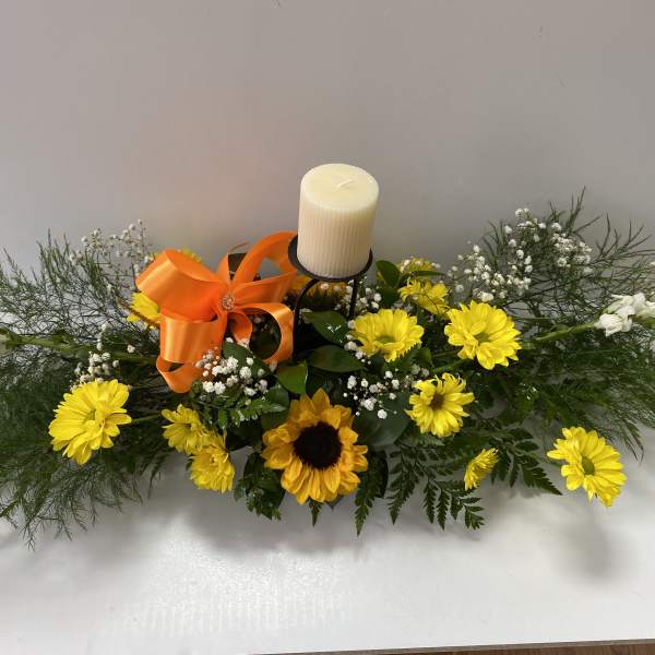 Yellow daisy and sunflower arrangement with a candle and orange ribbon