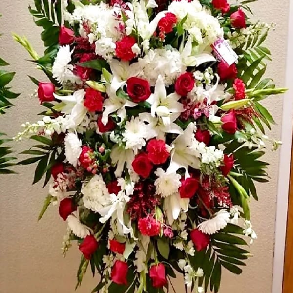 Large red and white funeral spray with roses and lilies