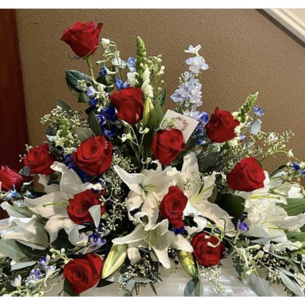 Large bouquet of red roses and white lilies with blue accents