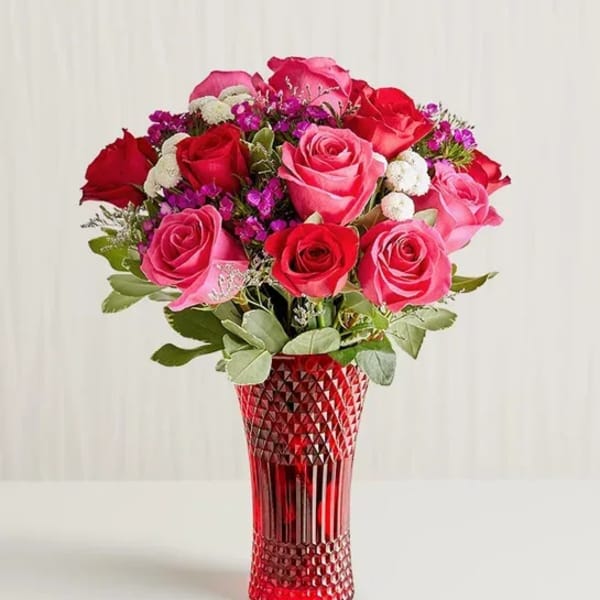 Bouquet of pink and red roses in a red textured vase