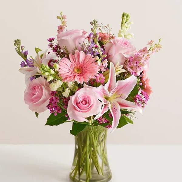 Pink mixed bouquet with roses and lilies in a clear glass vase
