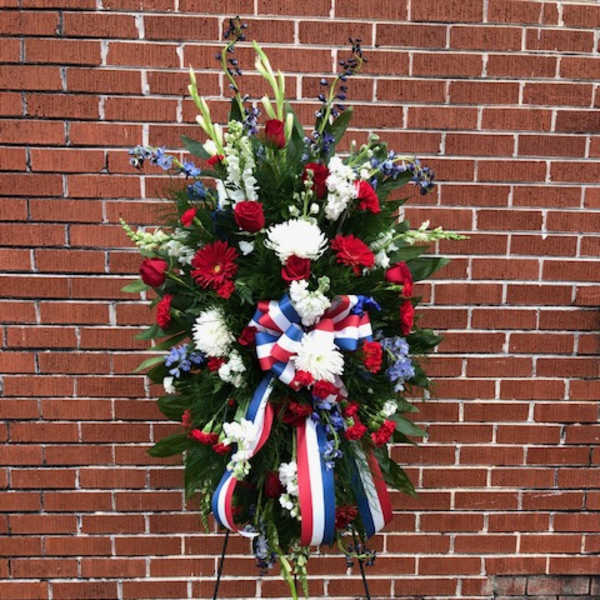 Standing patriotic floral wreath with red, white, and blue ribbons