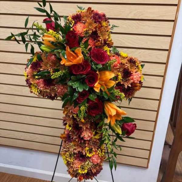 Cross-shaped floral standing spray with red, orange, and yellow blooms