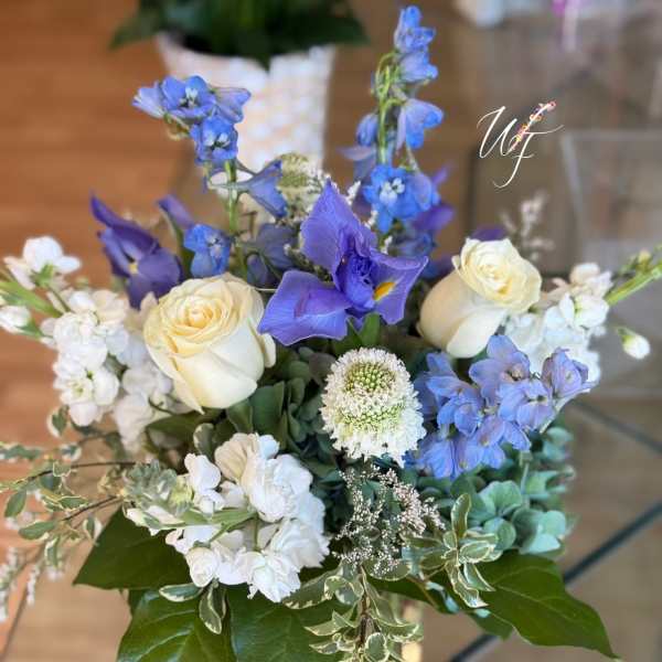 Blue and white floral arrangement in a clear glass vase