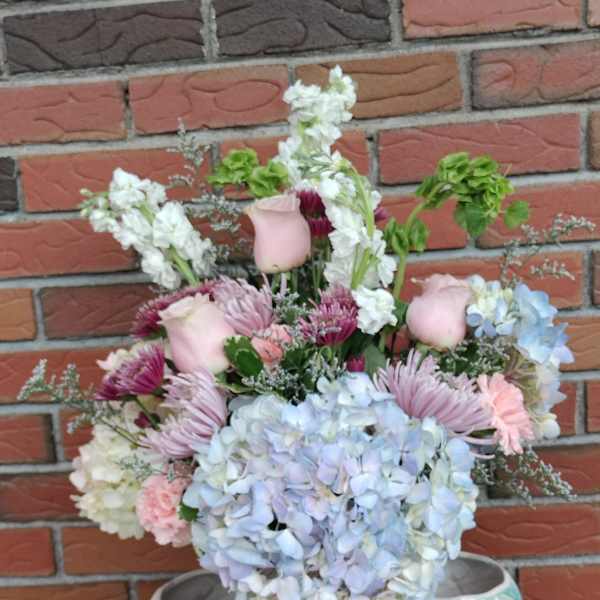 Pastel bouquet with hydrangeas, roses, and chrysanthemums in white vases