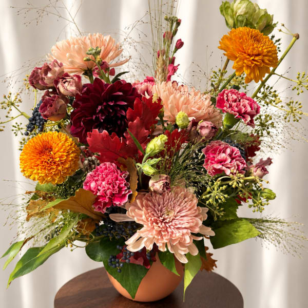 Mixed bouquet of chrysanthemums and carnations in a terracotta vase