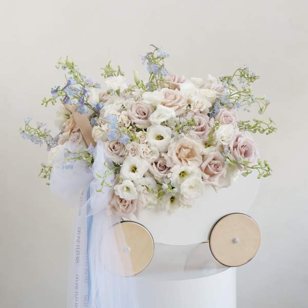 Pastel bouquet of roses and white blooms with blue accents