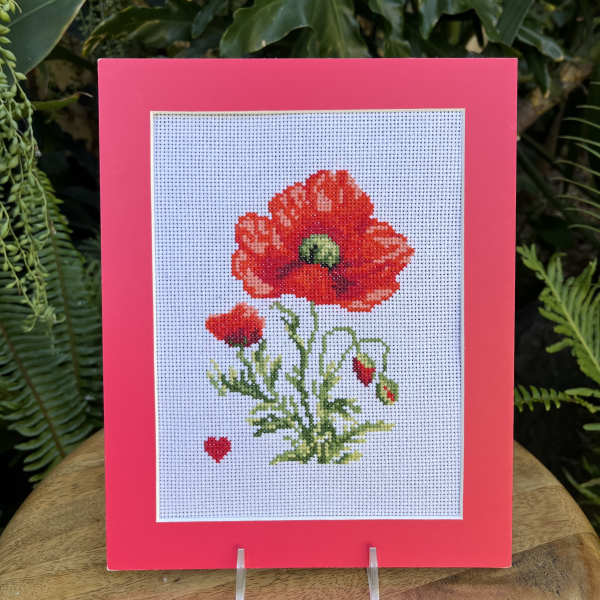 Framed cross-stitch of a red poppy flower