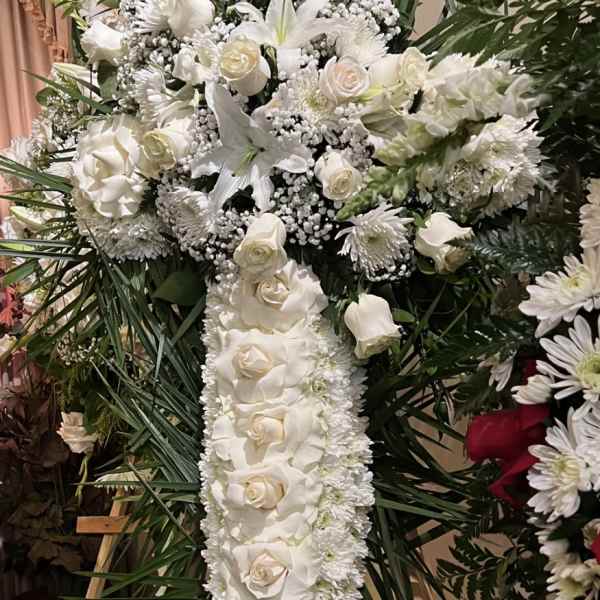 White floral standing cross arrangement with roses and lilies