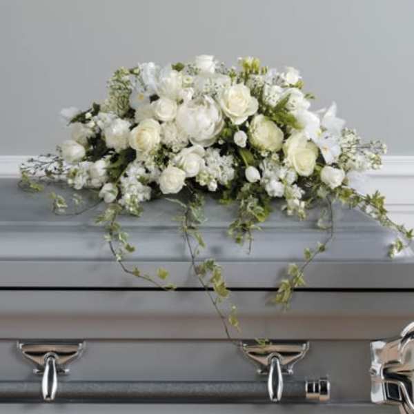 White floral casket spray with trailing greenery