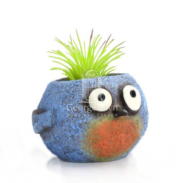 Blue owl-shaped planter with bright green grass-like plant