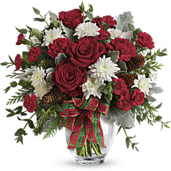 Red roses and white flowers in a glass vase with a plaid ribbon