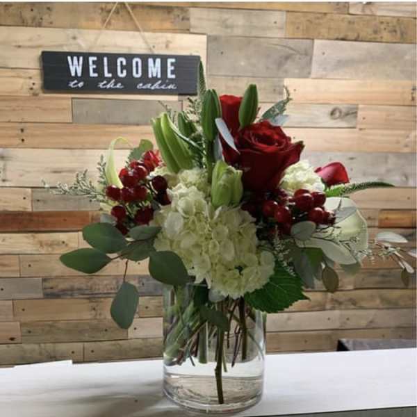 Red roses and white hydrangeas in a clear glass vase