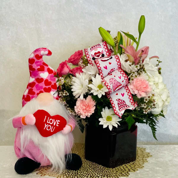 Pink and white flower arrangement with a heart-themed gnome plush