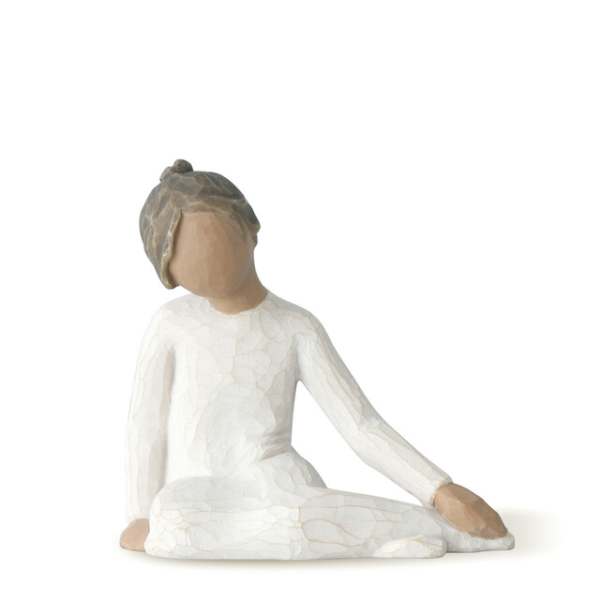 Faceless seated figurine in a white dress with a gray head covering