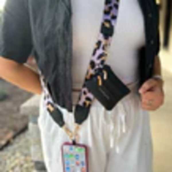 Person wearing a black-and-white lanyard with a phone case attached