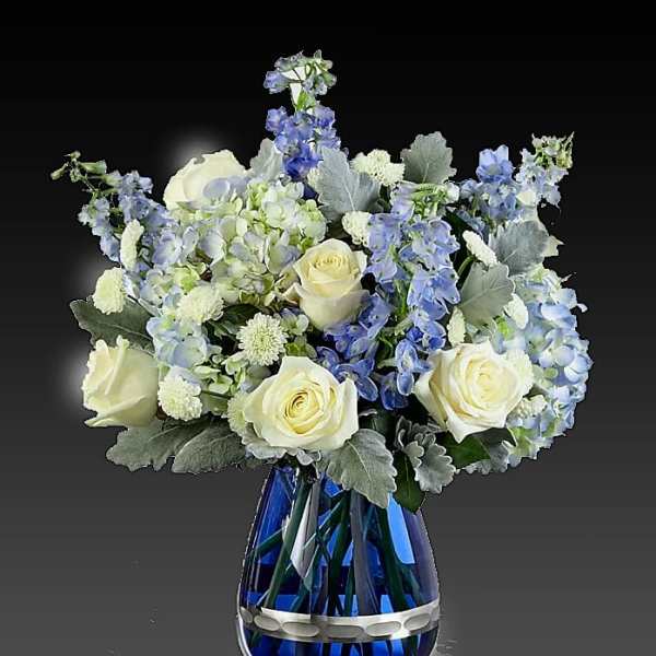 Blue and white floral arrangement in a cobalt glass vase