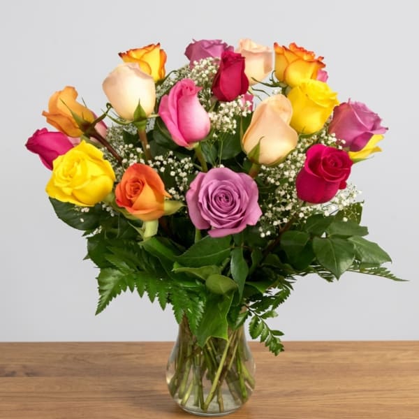 Mixed roses in a clear glass vase with baby's breath
