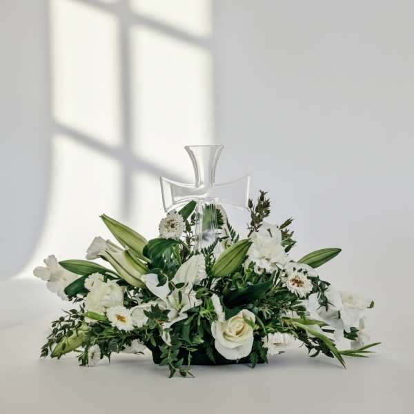 White floral arrangement with a clear cross centerpiece