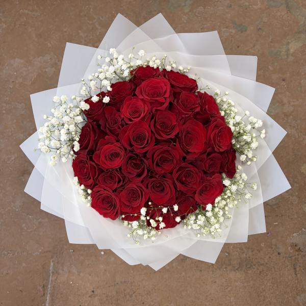 Bouquet of red roses with white baby's breath in white wrap