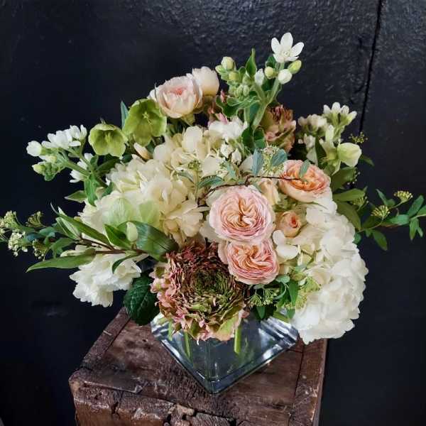 Blush and white floral arrangement in a square glass vase
