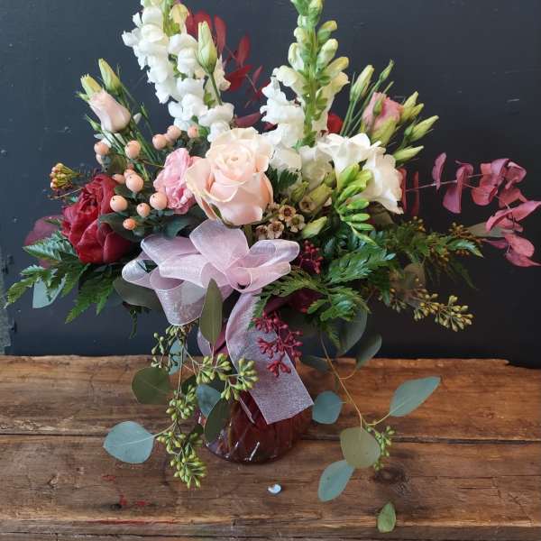 Mixed bouquet with pale pink and white flowers in a glass vase