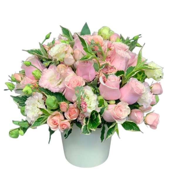 Pink roses and carnations arranged in a white vase