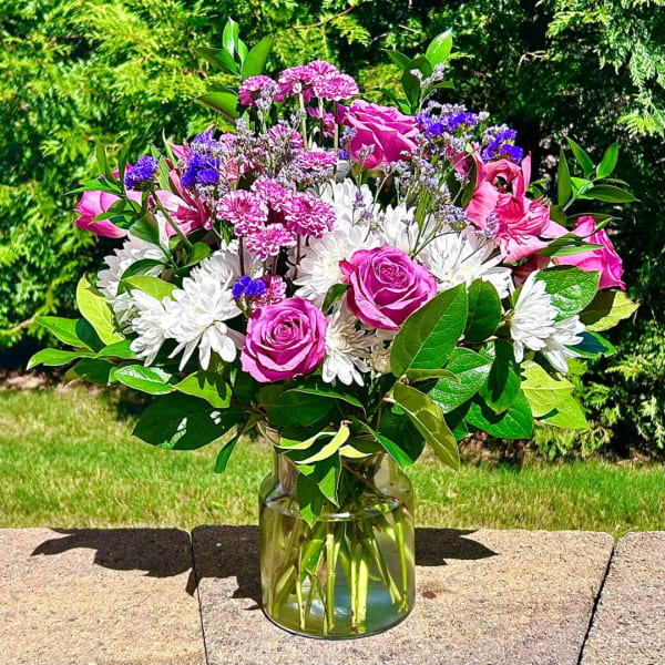Pink roses and white daisies in a clear glass vase