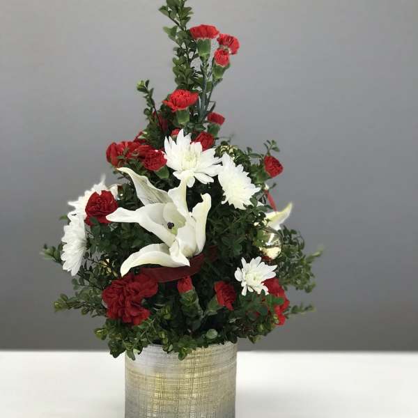 Red and white floral arrangement in a gold-toned container