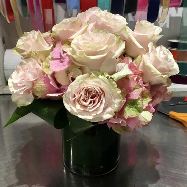 Blush roses arranged in a dark green vase