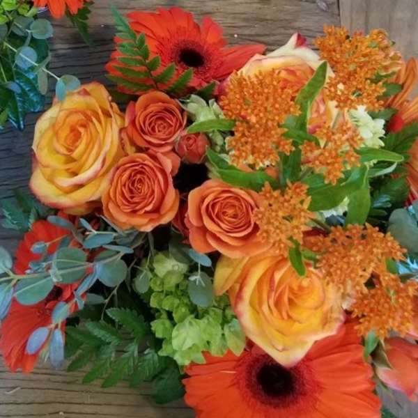 Bouquet of orange and yellow roses with orange gerbera daisies