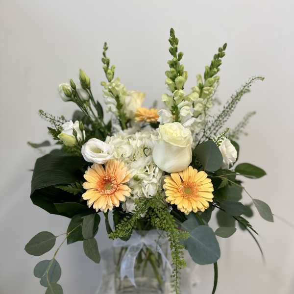 Bouquet of white and peach flowers in a glass vase