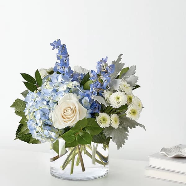Blue and white flower arrangement in a clear glass vase