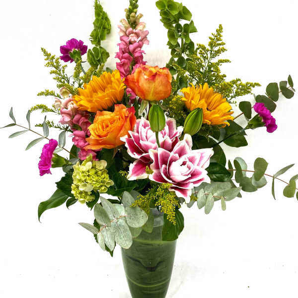 Colorful mixed flower arrangement in a green vase