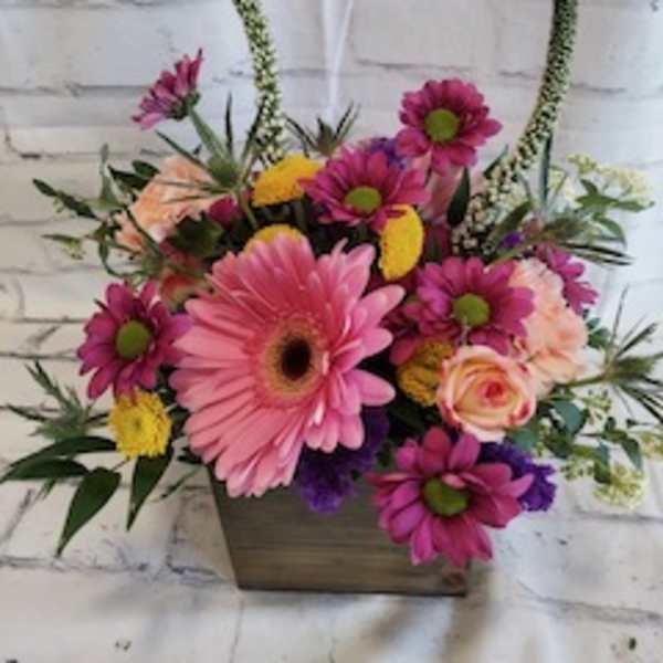Pink gerbera daisies and mixed blooms in a wooden box arrangement