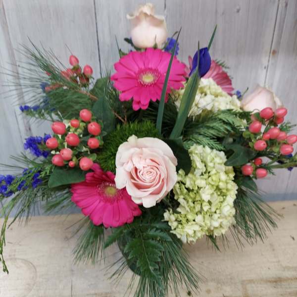 Pink roses and gerbera daisies in a mixed floral arrangement
