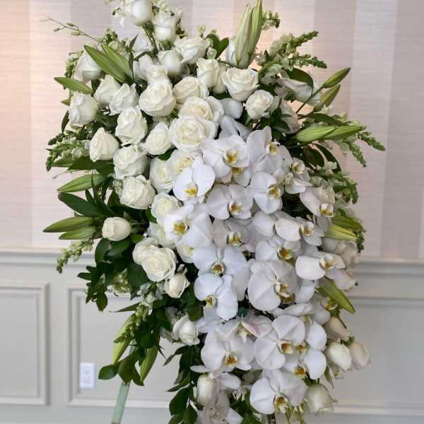 White roses and orchids in a large standing spray
