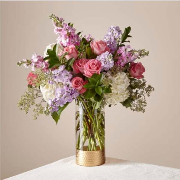 Pink and lavender flower arrangement in a clear glass vase