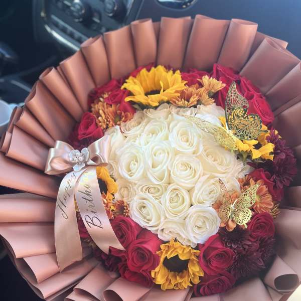 Bouquet of white and red roses with sunflowers and a birthday ribbon