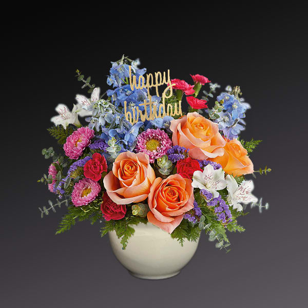 Mixed bouquet in a white vase with a happy birthday sign
