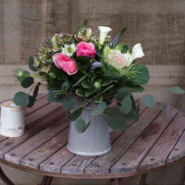 Pink and white floral arrangement in a gray vase