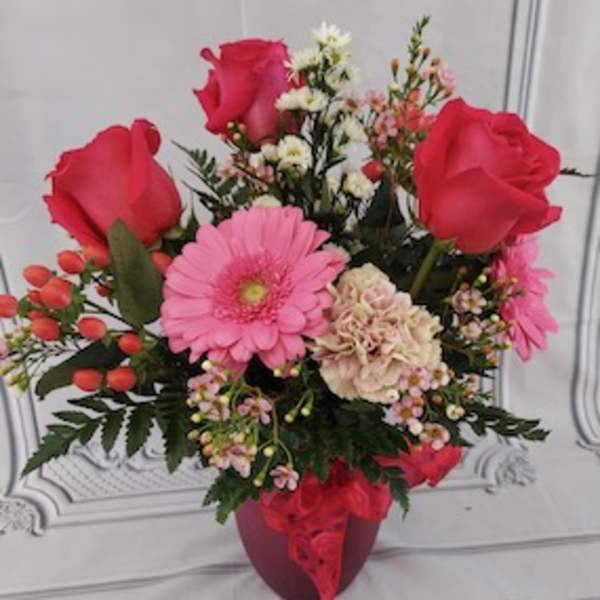 Pink and red flower arrangement in a red vase