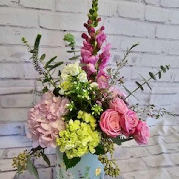 Pink and yellow mixed flower arrangement in a painted vase