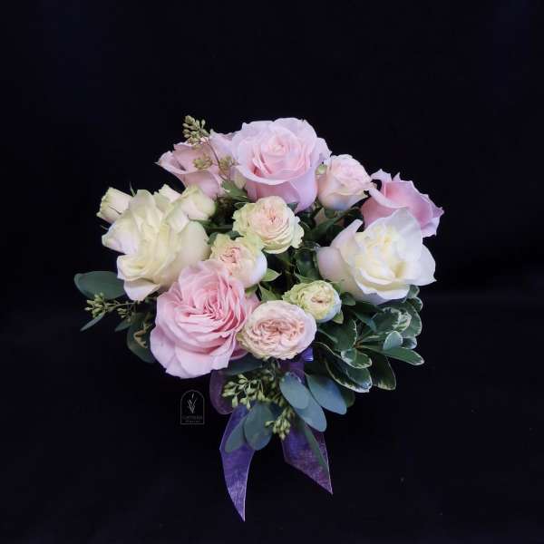 Bouquet of pale pink and white roses with a purple ribbon
