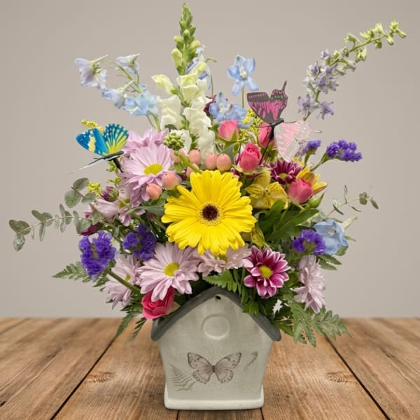 Colorful mixed bouquet in a butterfly-decorated ceramic vase