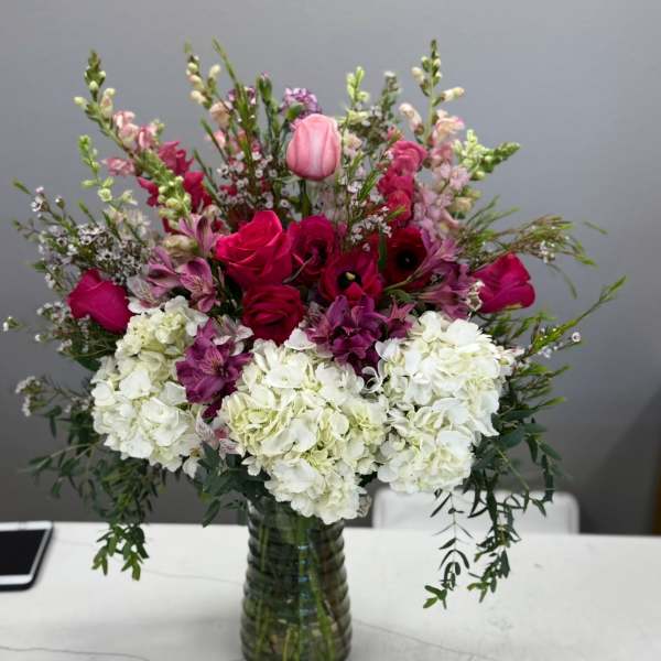 Mixed pink and white floral arrangement in a glass vase